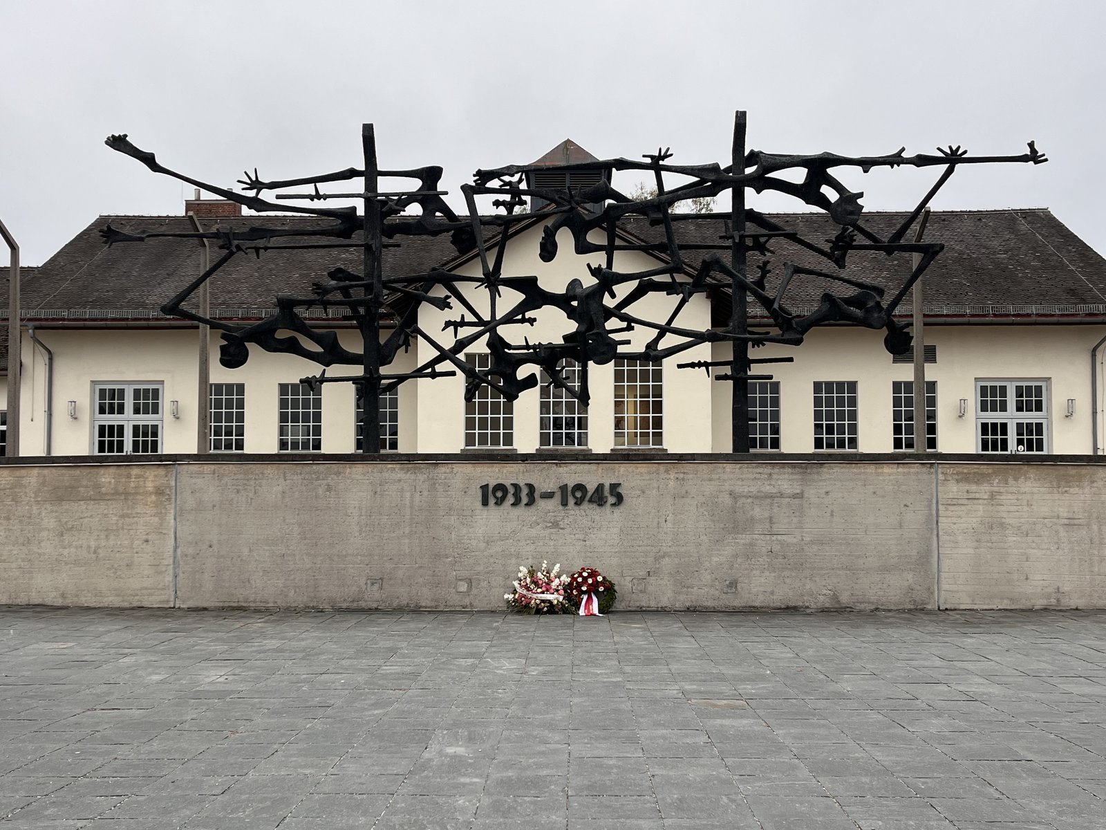 Il Monumento internazionale di Nandor Glid davanti all'ex edificio di servizio del campo, oggi museo del Memoriale di Dachau